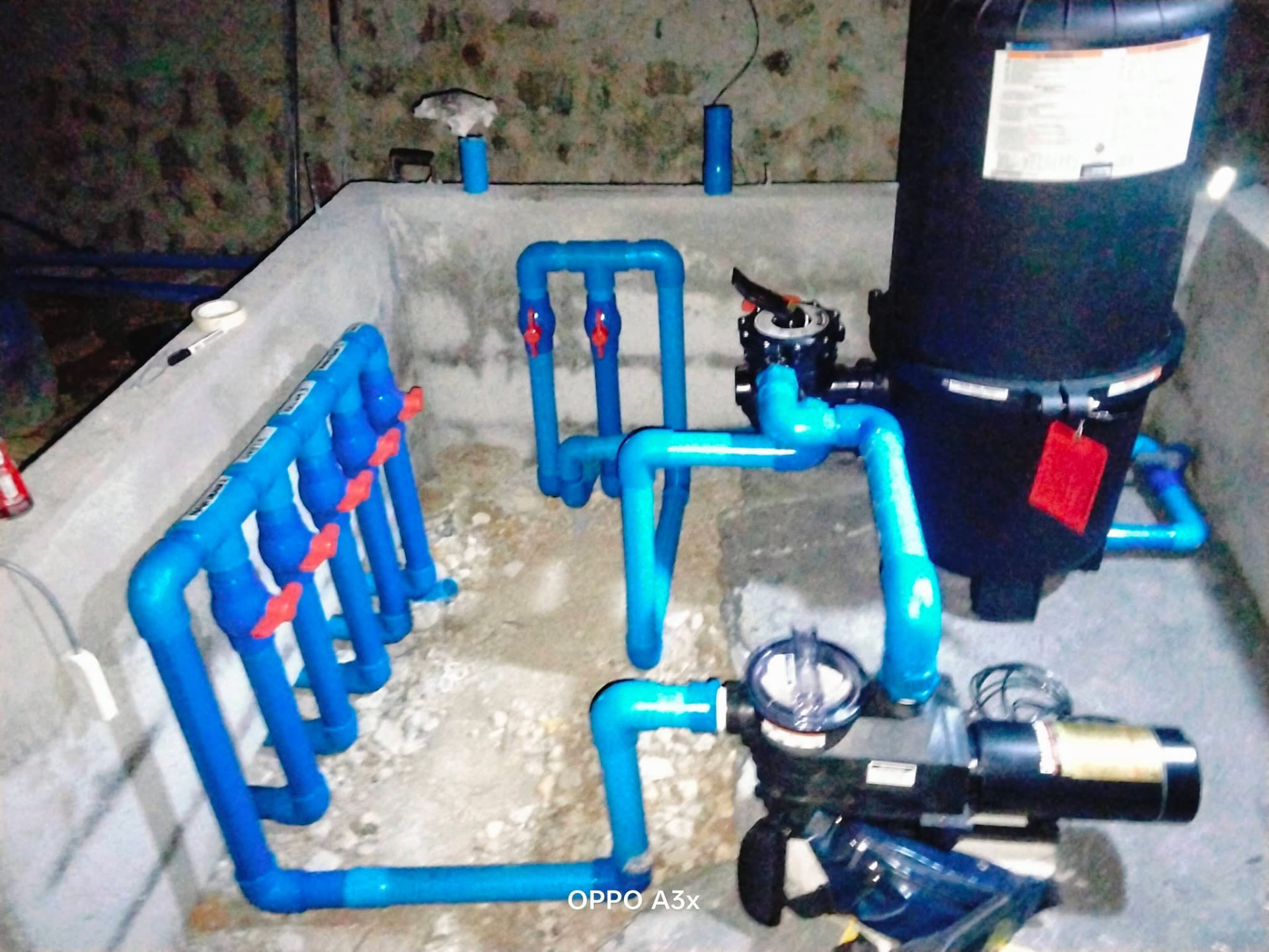 New pool filter and blue PVC pipework installed in an equipment room