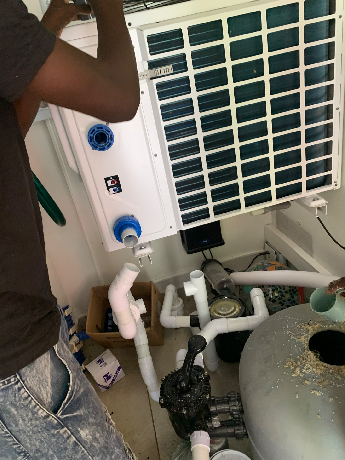 Technician installing pool pump and heat pump equipment with neat pipework